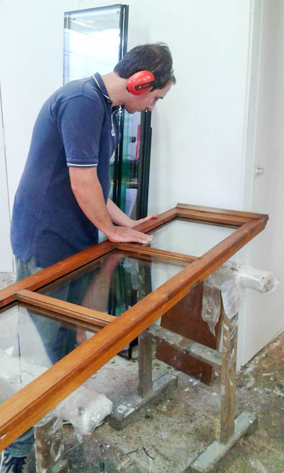 Sostituzione dei vetri in un infisso durante il restauro
